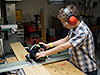 Lan-man cutting some wood for his box
